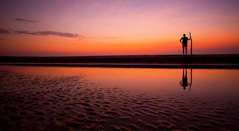 Silhouette of a man on beach at sunset